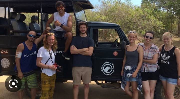 A group of travellers beside their safari jeep in Sri Lanka