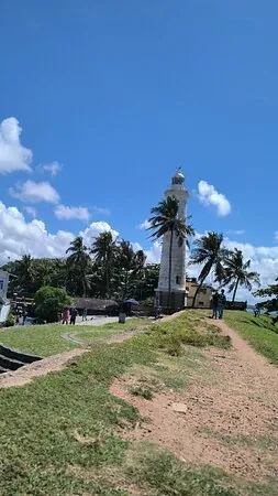 A coastal lighthouse beneath a bright blue Sri Lankan sky